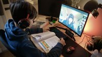 Teenage boy participating in a group discussion via video chat during distance learning