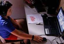 Elementary student working on his laptop at home