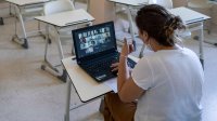 Teacher leading a virtual lesson in her empty classroom