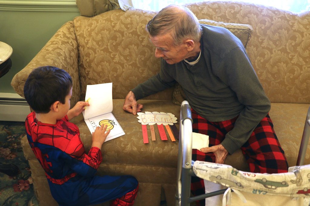 Photo of child and elderly person looking at books