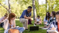 Photo of teacher and students writing outside