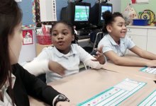 Students are talking to a teacher in a classroom