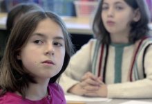 Students is paying close attention to a teacher in a classroom. 