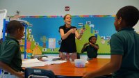 A teacher is working with her primary students in a classroom.