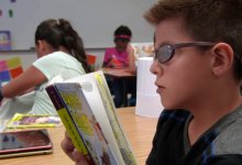 Student is reading a book in a classroom.