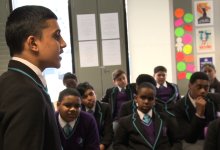 A student is speaking in front of the classroom.