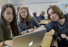 Girl students are working on a computer.