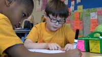 Two primary school students are working on an assignment together.