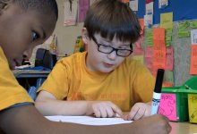 Two primary school students are working on an assignment together.