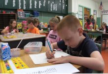 photo of a student writing at a desk