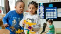 Two kindergartners working on a marble project in class