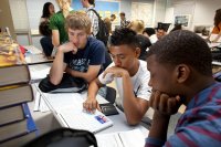 High school students working on a laptop together