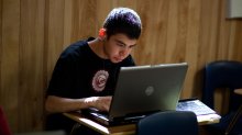 High school student working on a laptop in his classroom