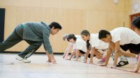 A teacher and students in starting position to sprint