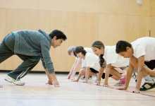 A teacher and students in starting position to sprint