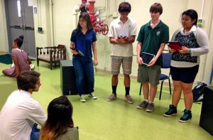 Students reading lines with a couple sitting on the floor listening