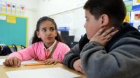 Elementary students working on a math assignment together