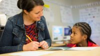 Elementary school teacher working with student