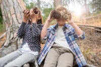 Children playing with pine cones in forest