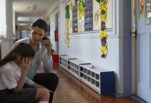 photo of a teacher and student having a hallway discussion