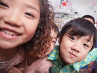 Close up of three children smiling at the camera