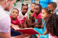 Teacher reading a picture book to elementary school students