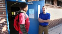 Teacher talks to high school student at his classroom door