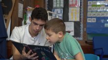 Two boys reading a book together