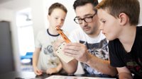 A father and his two sons do a project together.