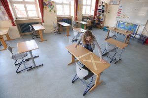 Staff tape off social-distancing markings during preparations for reopening the temporarily-closed Schloss-Schule elementary school on April 21, 2020 in Heppenheim, Germany.