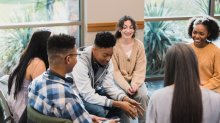 A group of teen students sitting in a classroom discussion circle