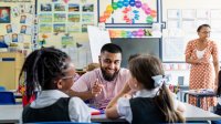 Two preschool teachers working with students in class