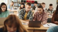 High school students working on a laptop together