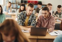 High school students working on a laptop together