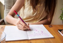 Teenager drawing in a notebook at home