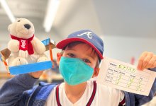 Student proudly holding his stuffed animal project