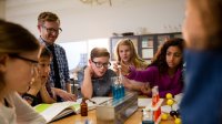 Middle school science teacher working with a small group of students