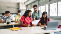 High school teacher works with students in class