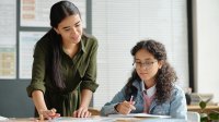 Teacher and student looking at school work together