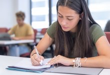 High school student writing at her desk