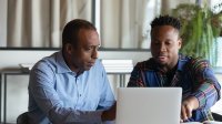 Two colleagues working on a laptop together