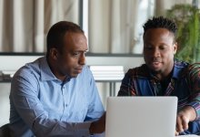 Two colleagues working on a laptop together