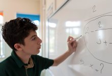 Student working on math problems on a whiteboard