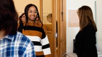 High school teacher greeting students at the classroom door