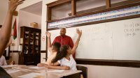 Students raising their hands during math class