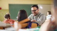 Teacher kneeling down and talking to student