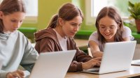 Students working at laptops together