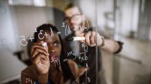 People writing math problems on a window