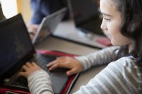 Middle school student working on a laptop