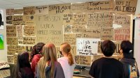 Students looking at sign about homelessness